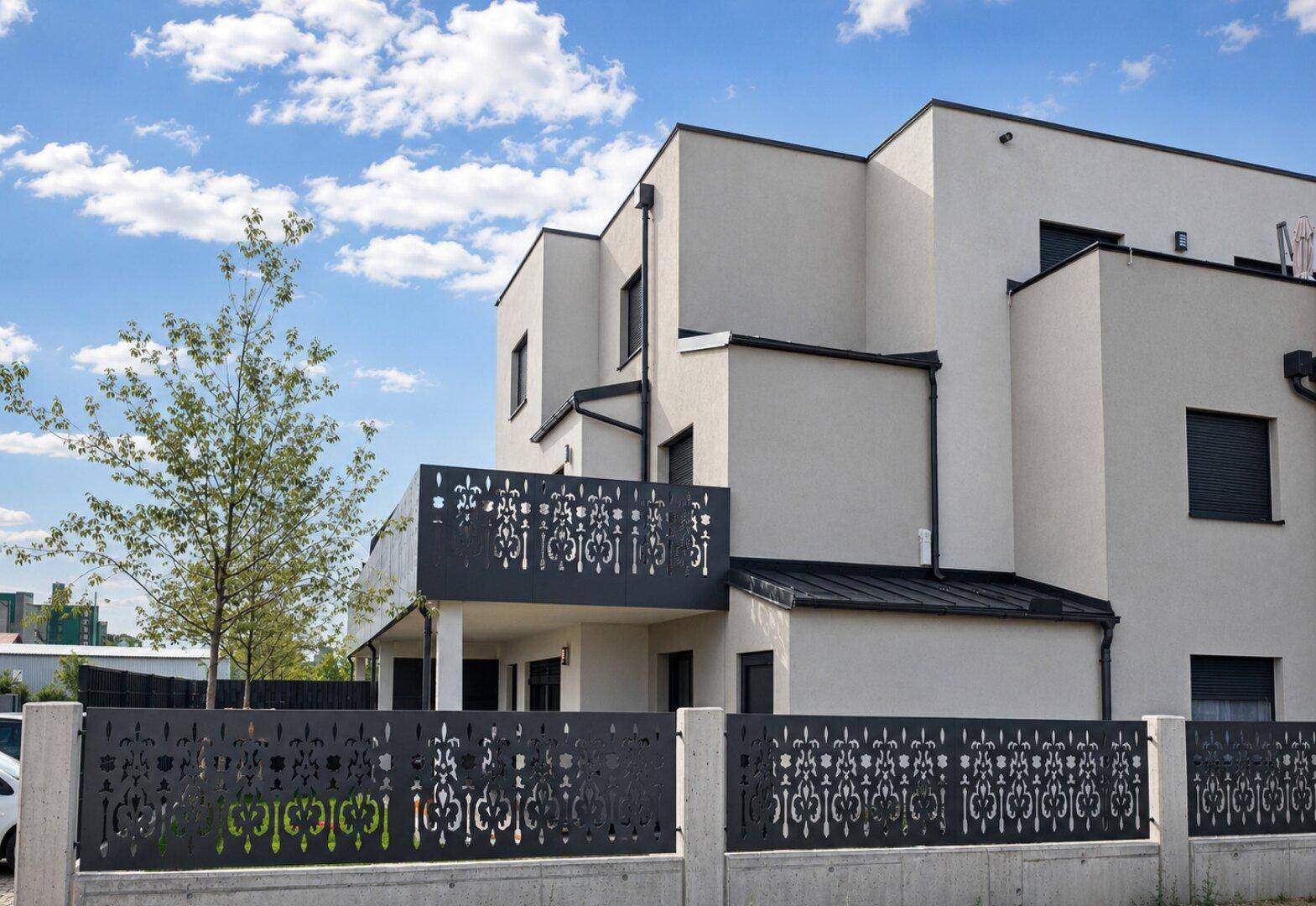 Moderne Architektur mit klaren Linien und dekorativen Balkongeländern unter blauem Himmel.