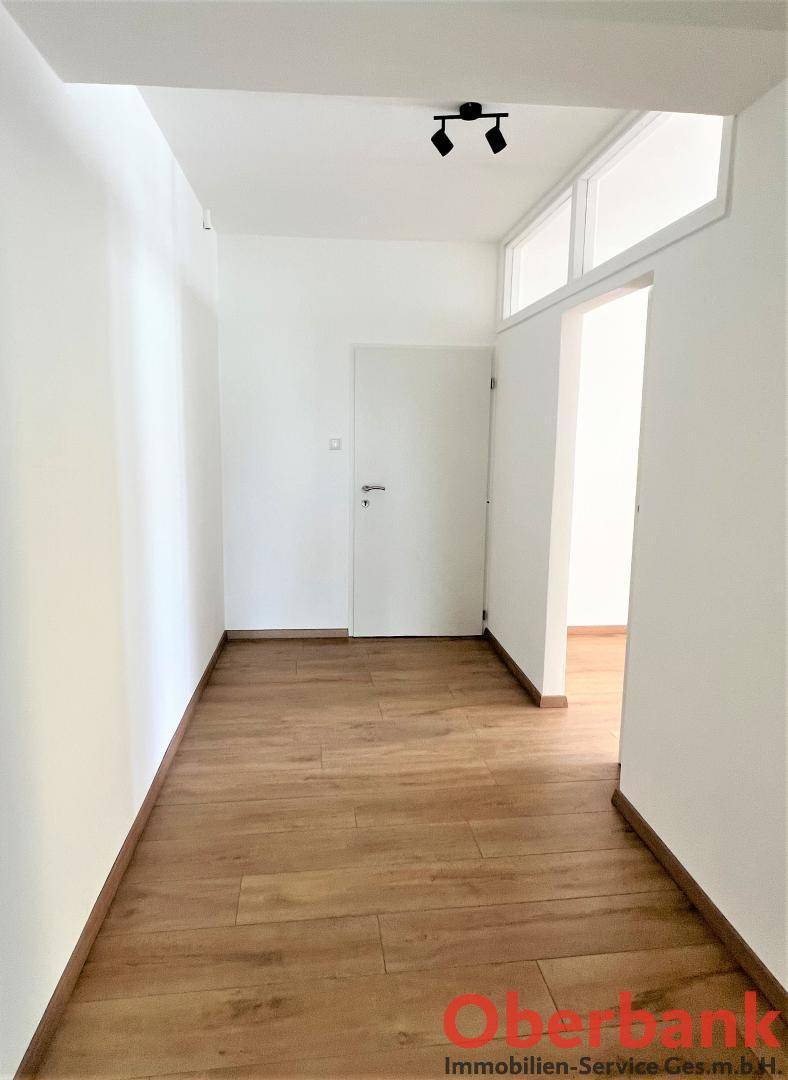 Geräumiger Flur mit hellem Laminatboden und Zugang zu den weiteren Zimmern der Wohnung.