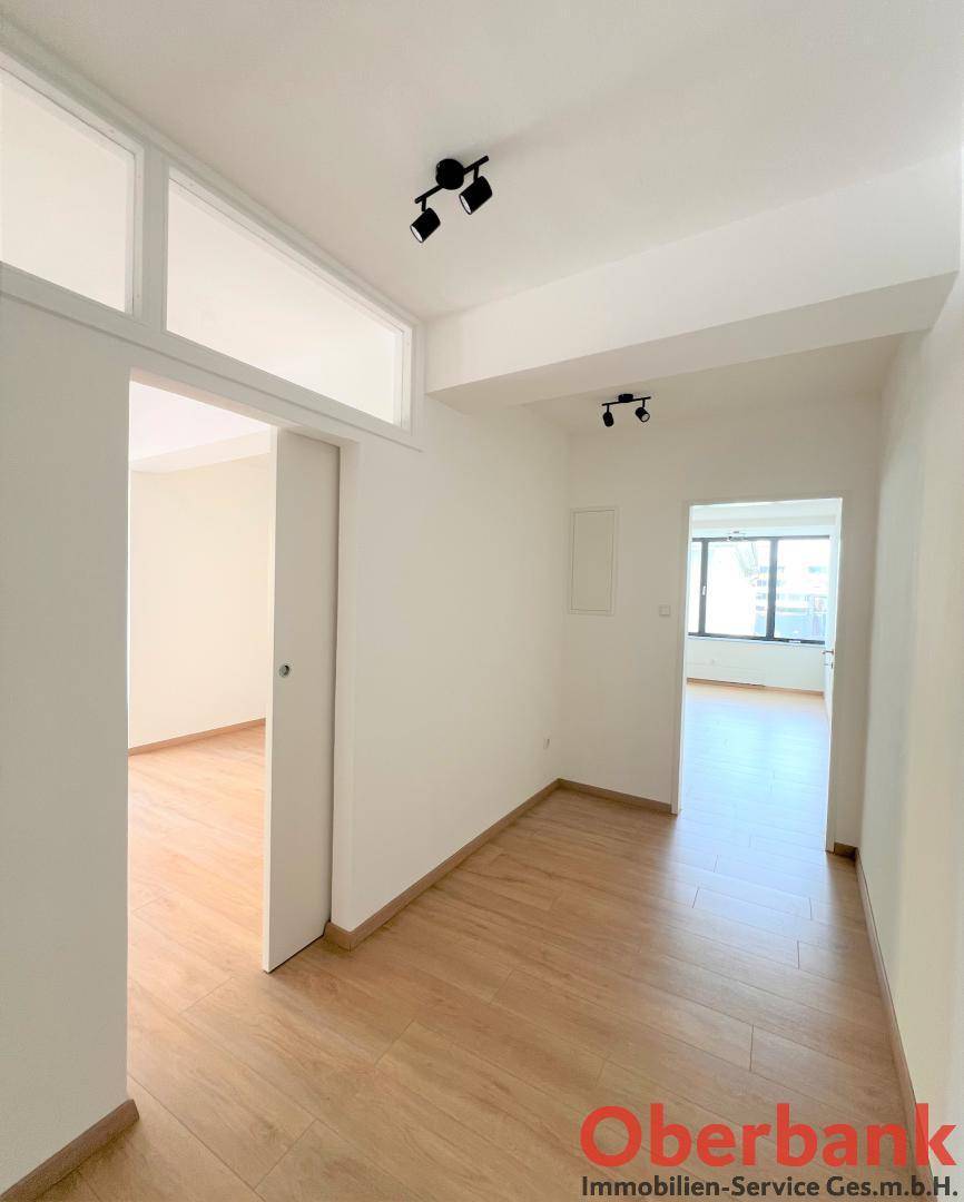 Heller Flur mit Laminatboden und Zugang zu verschiedenen Räumen der Wohnung.