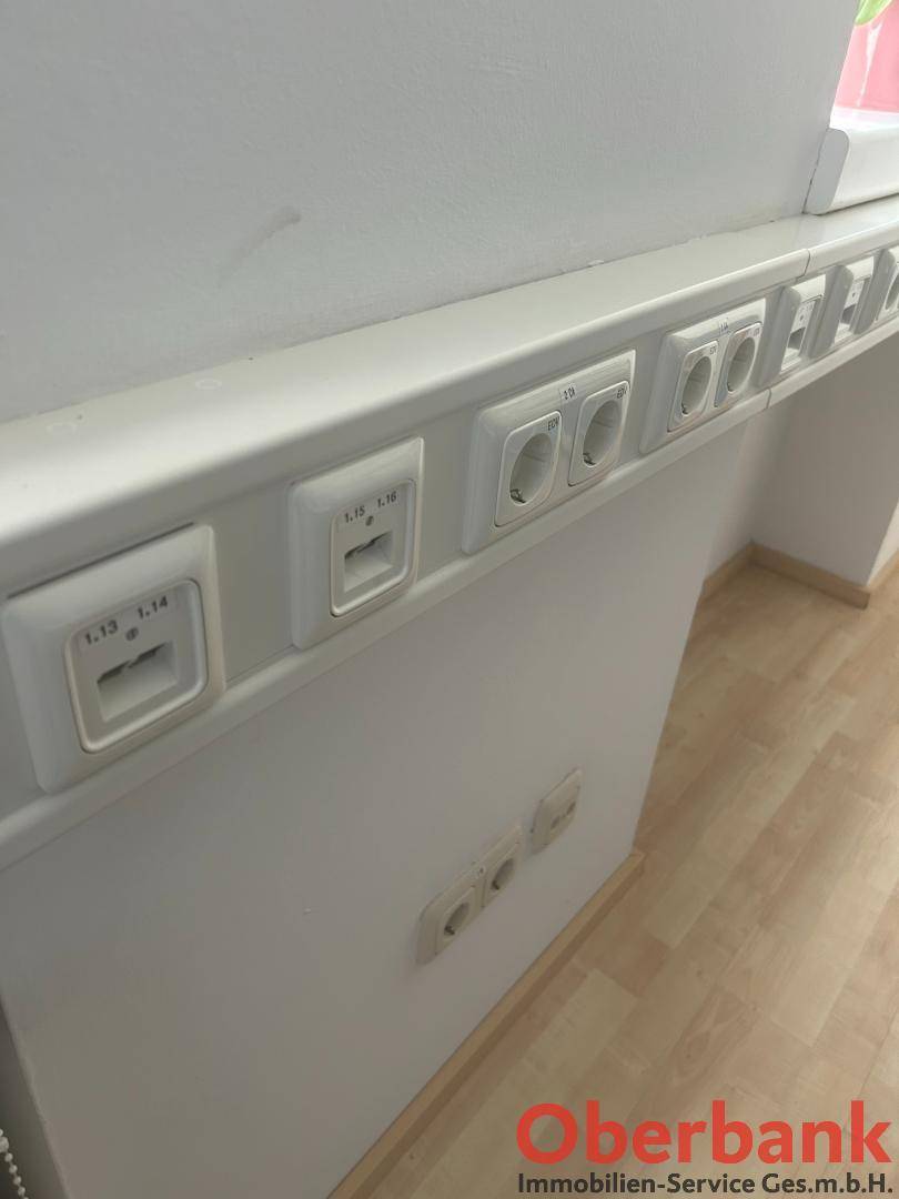 Detailaufnahme von Steckdosen und Netzwerkanschlüssen an einer Wand über dem Fußboden.