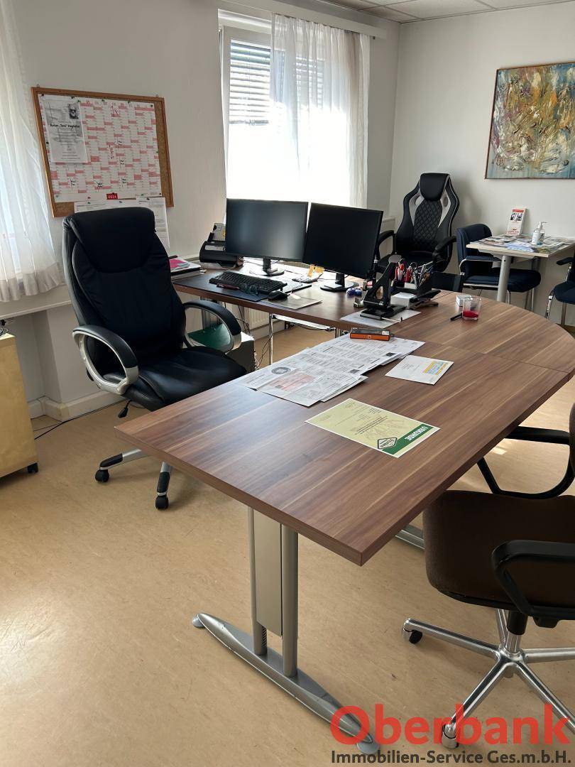 Detailansicht eines Arbeitsplatzes im Büro mit Schreibtisch, Bürostuhl und Computermonitoren.