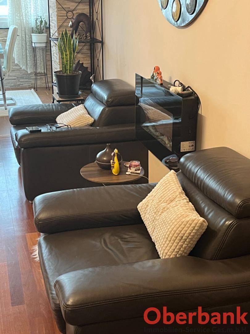 Komfortable Ledersessel im Wohnzimmer mit Holzboden und dekorativen Elementen.
