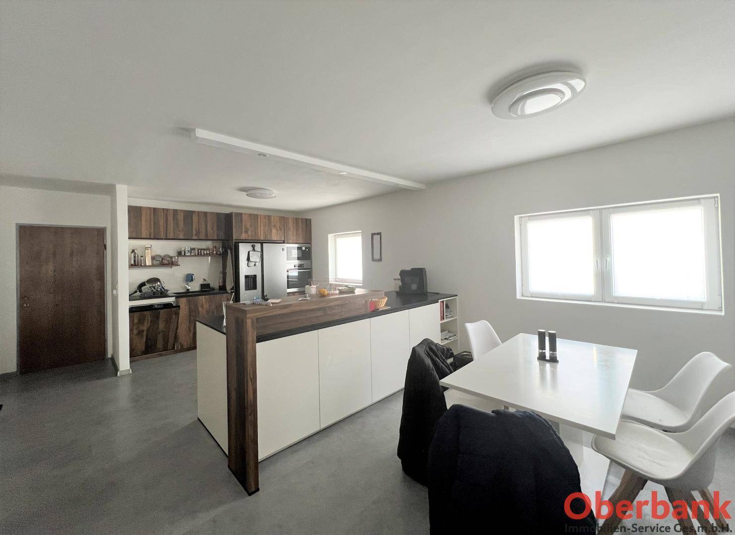 Moderne Küche mit Holzakzenten, integriertem Essbereich und viel natürlichem Licht.