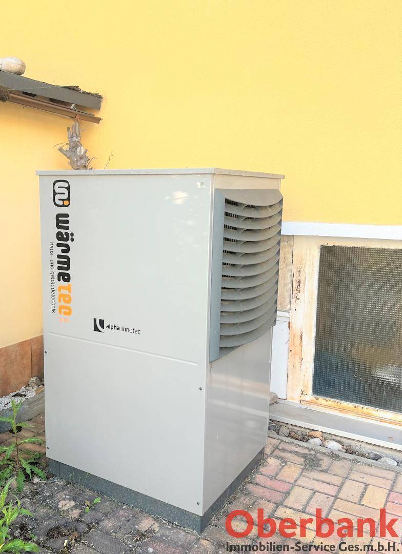 Moderne Wärmepumpe an der Außenwand des Hauses, sorgt für effiziente Heizung.