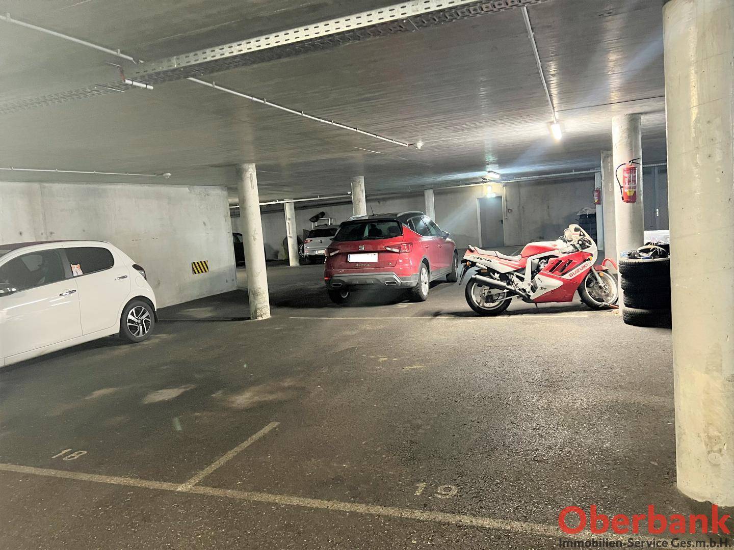 Tiefgarage mit mehreren Stellplätzen für Fahrzeuge, gut beleuchtet und zugänglich.