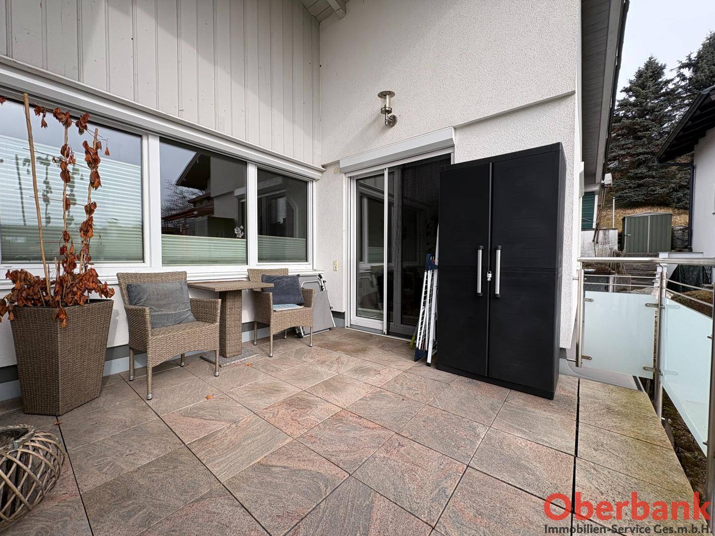 Geräumige Terrasse mit Fliesenboden und Sitzgelegenheiten, ideal für Entspannung im Freien.