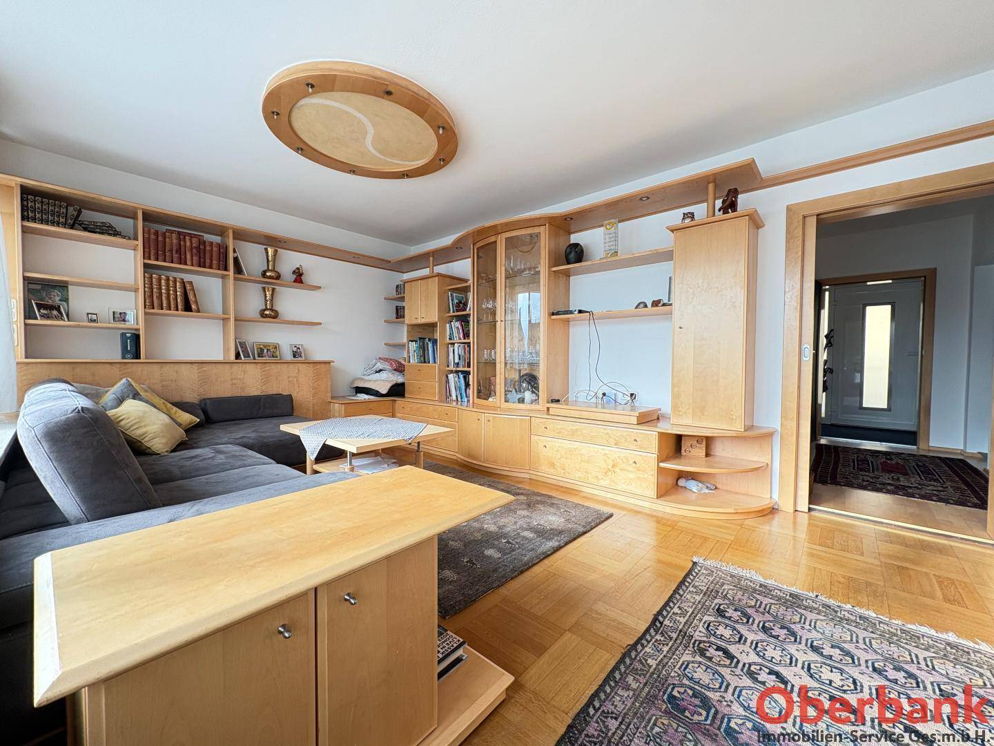 Gemütliches Wohnzimmer mit umfangreichen Holzregalen und integrierten Schränken.