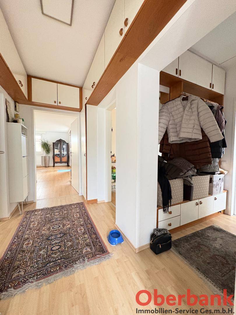 Flur mit Einbauschränken und Garderobe, führt zu weiteren Räumen.