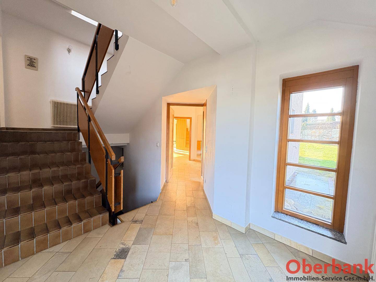 Geräumiger Flur mit gefliester Treppe und Zugang zu weiteren Räumen im Haus.