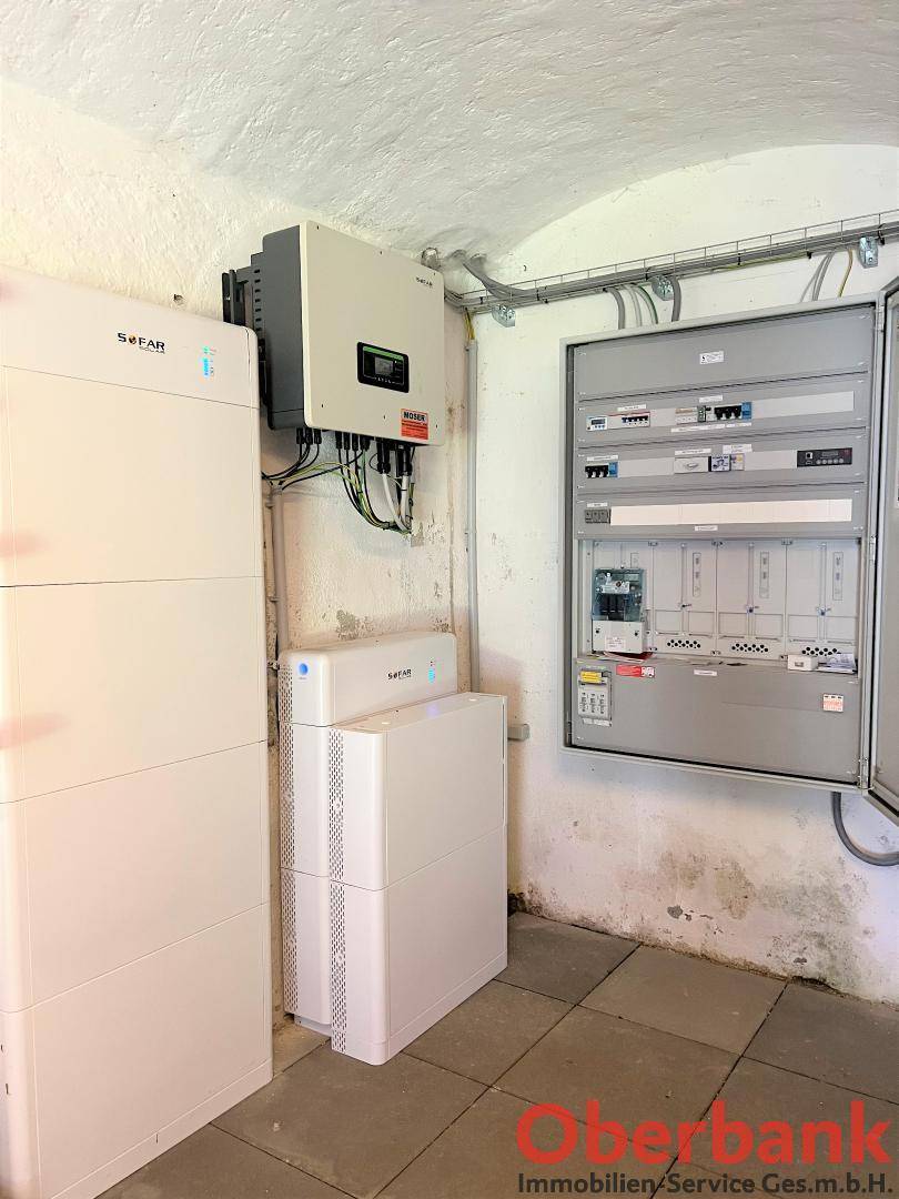 Moderner Technikraum mit Photovoltaik-Wechselrichter, Batteriespeichern und einem großen Sicherungskasten.