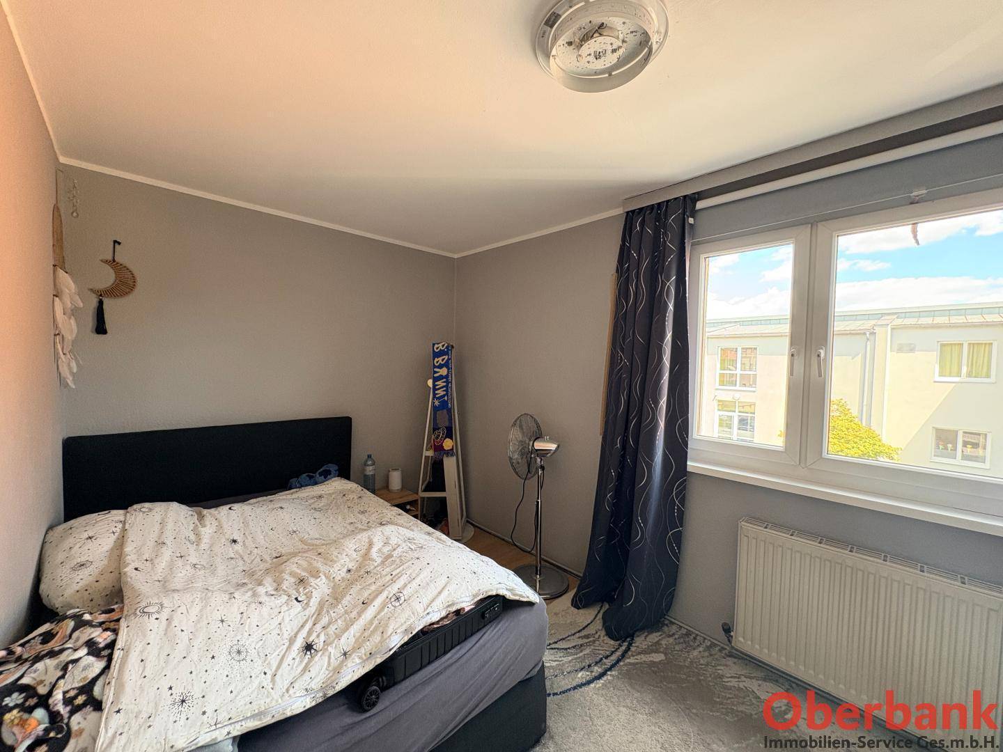 Schlafzimmer mit Bett, Fenster und Heizkörper, ausgestattet für eine ruhige Nacht.