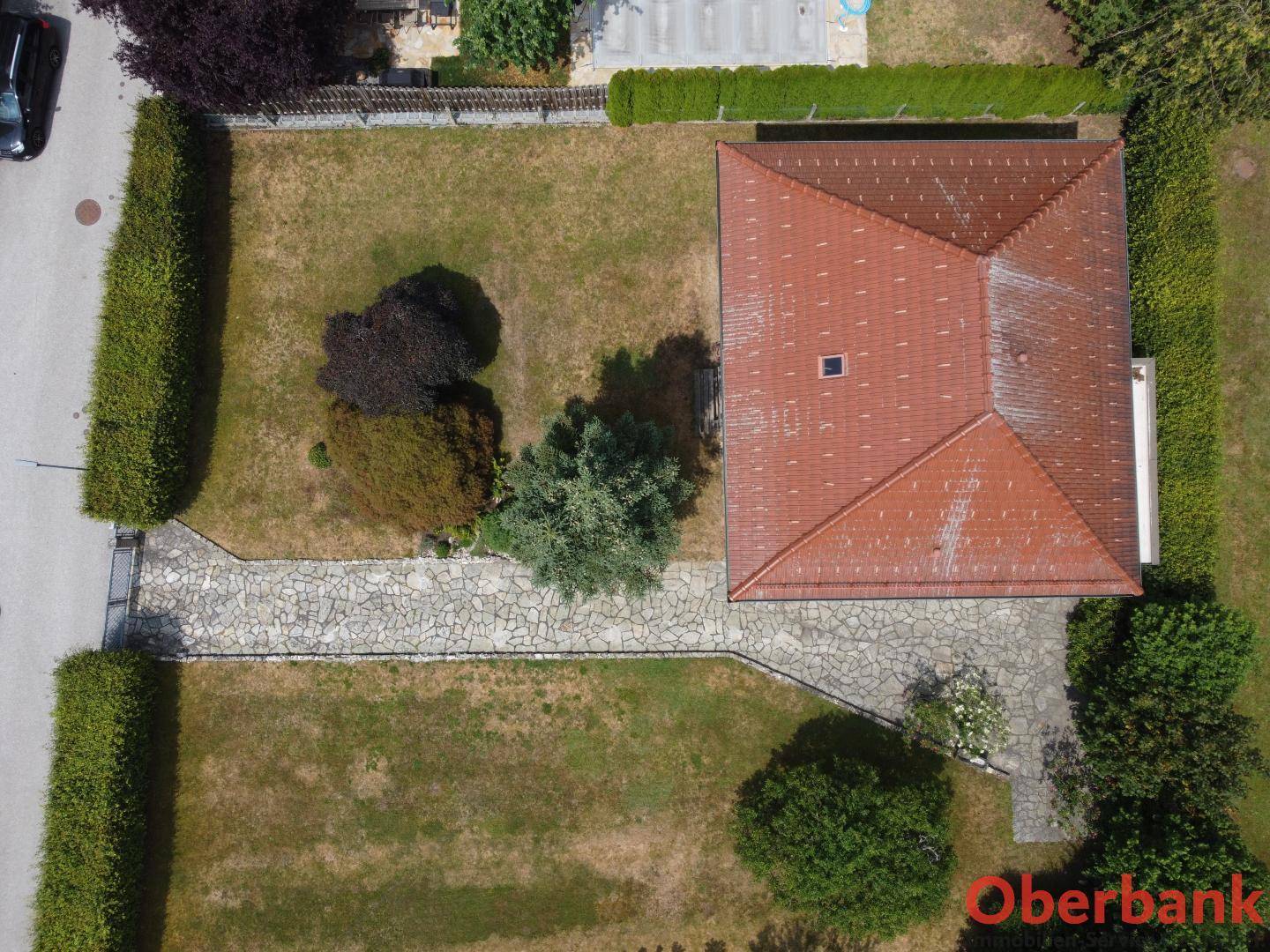 Draufsicht auf das Einfamilienhaus mit gepflegtem Garten und gepflastertem Weg.