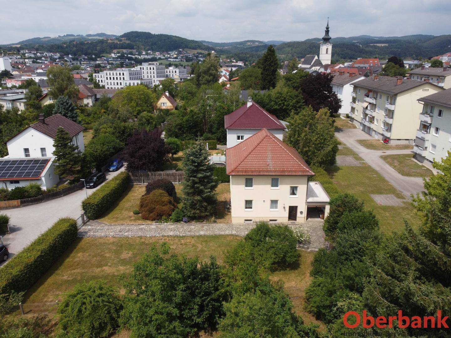 Weitläufige Luftaufnahme des Hauses mit Garten und Panoramablick auf die Stadt und Landschaft.