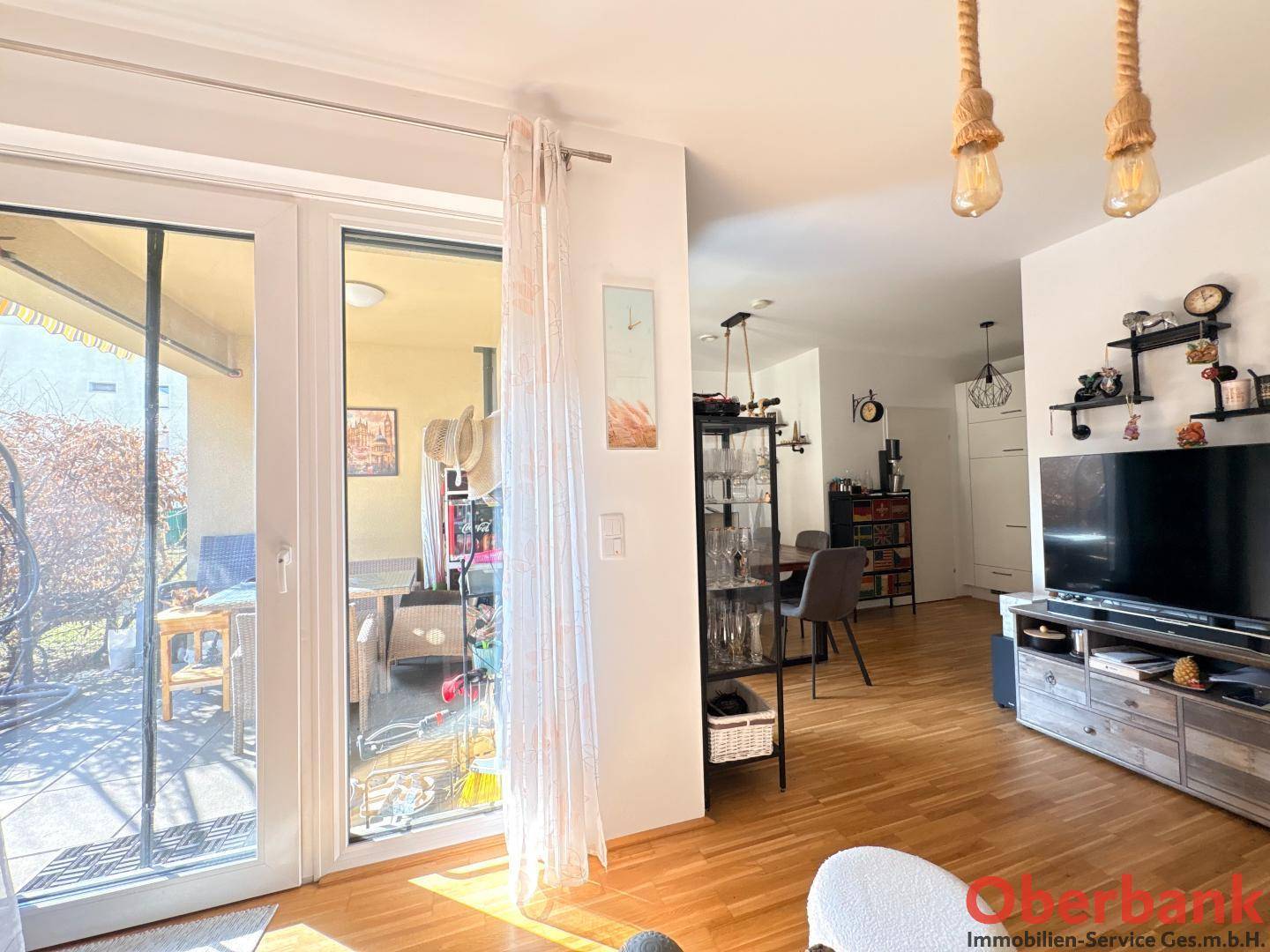 Lichtdurchfluteter Wohnbereich mit Zugang zur Terrasse durch große Glas-Schiebetüren.