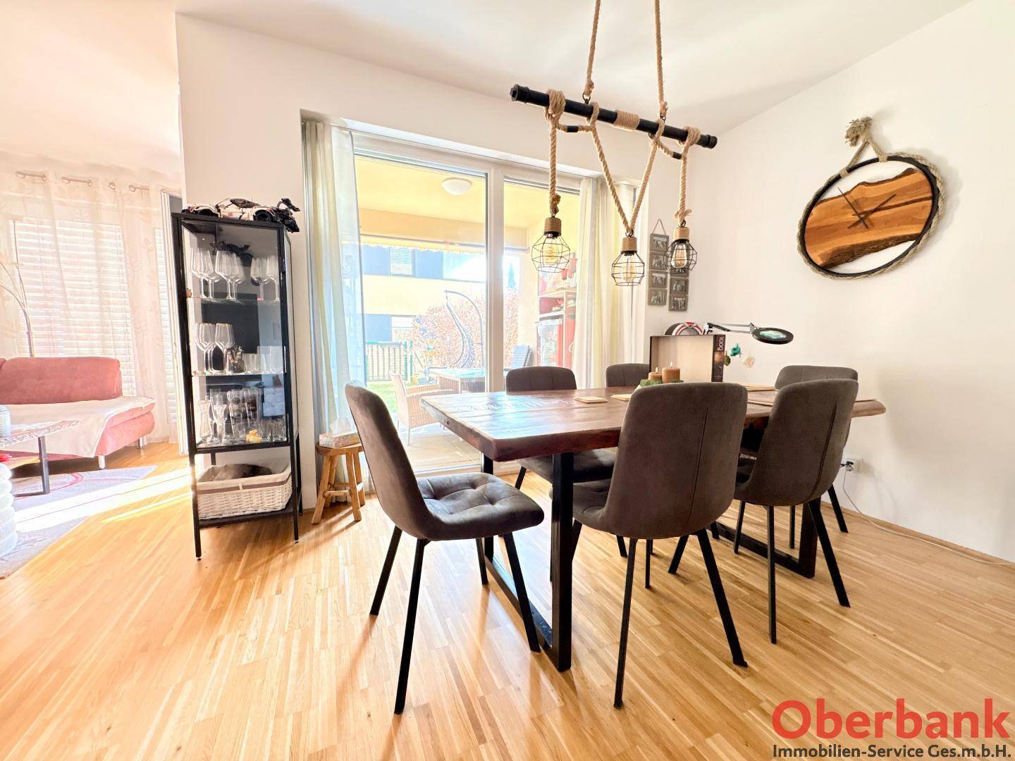 Heller Essbereich mit Holztisch, Designer-Pendelleuchte und Zugang zur Terrasse.