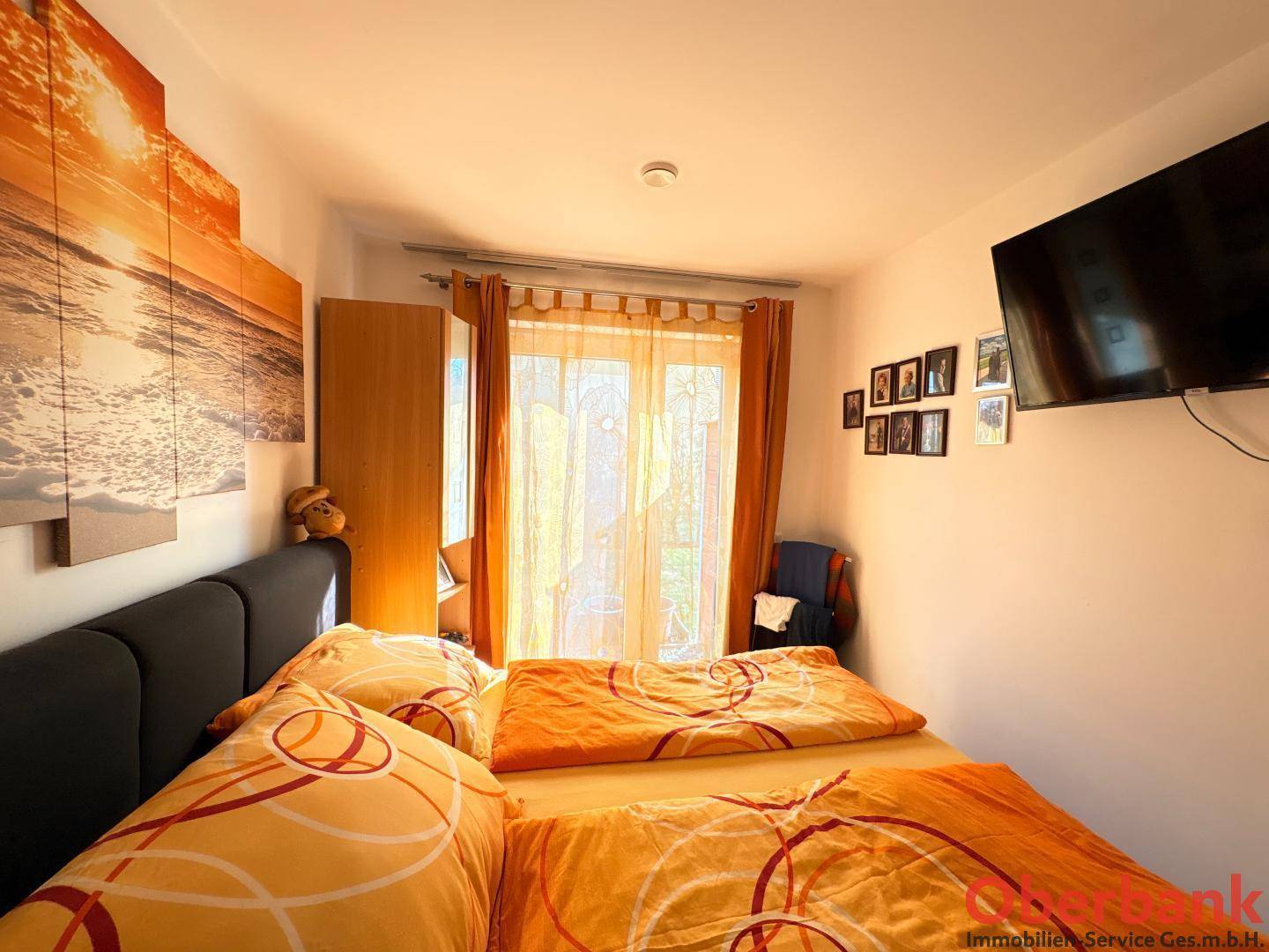 Gemütliches Schlafzimmer mit Doppelbett, warmen Farben und Zugang zu einem Außenbereich.