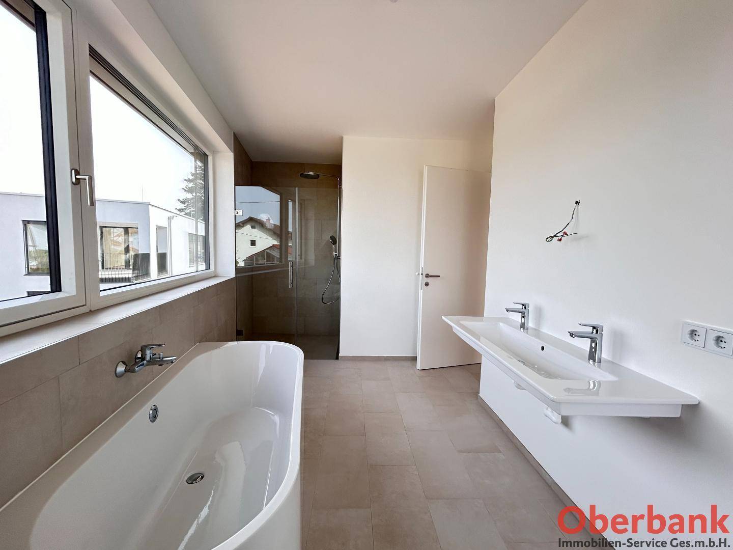 Geräumiges Badezimmer mit Doppelwaschbecken, freistehender Badewanne und begehbarer Dusche.