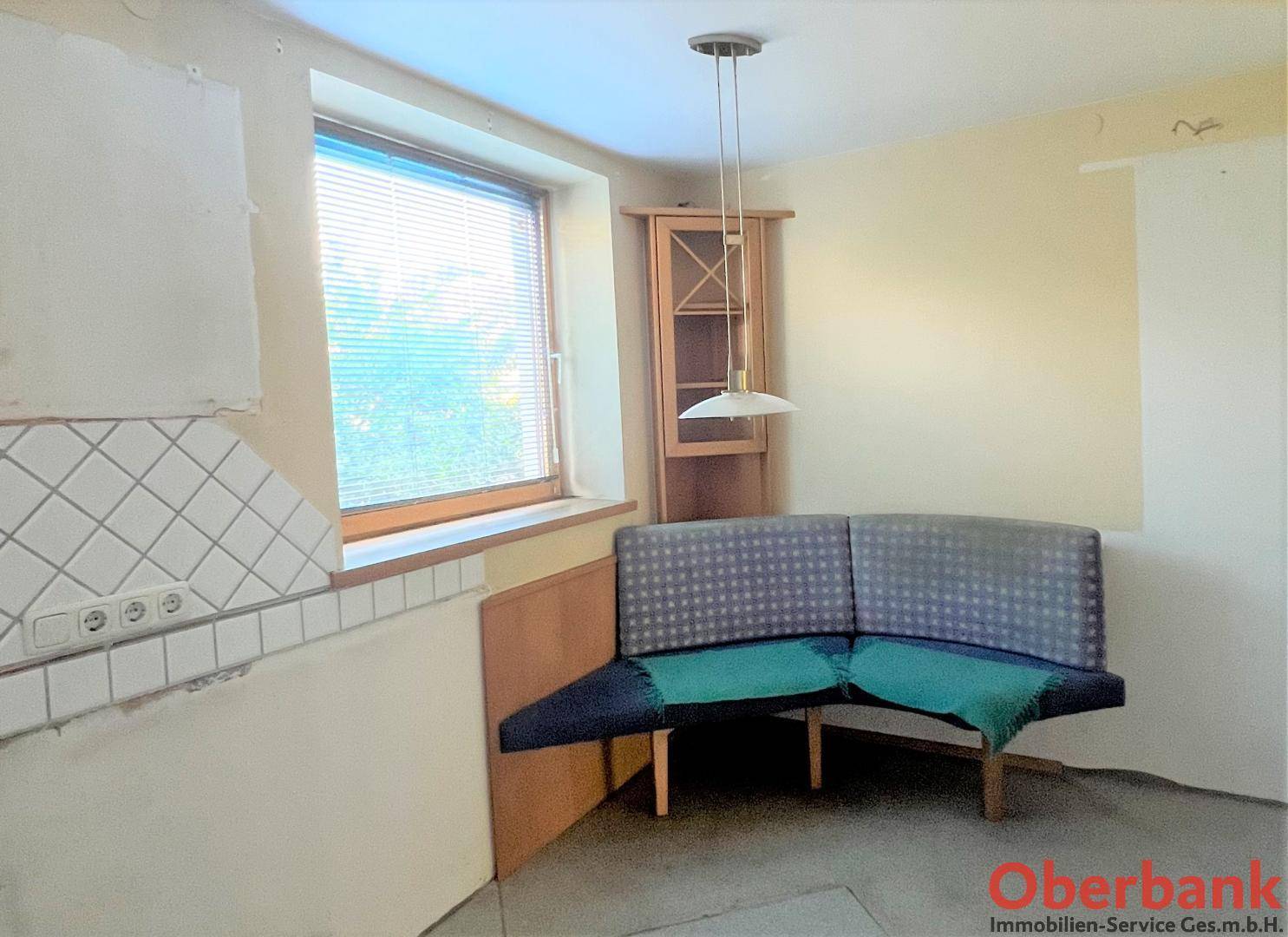 Einfache Küche mit Essbereich und Fenster, bereit für eine individuelle Modernisierung.