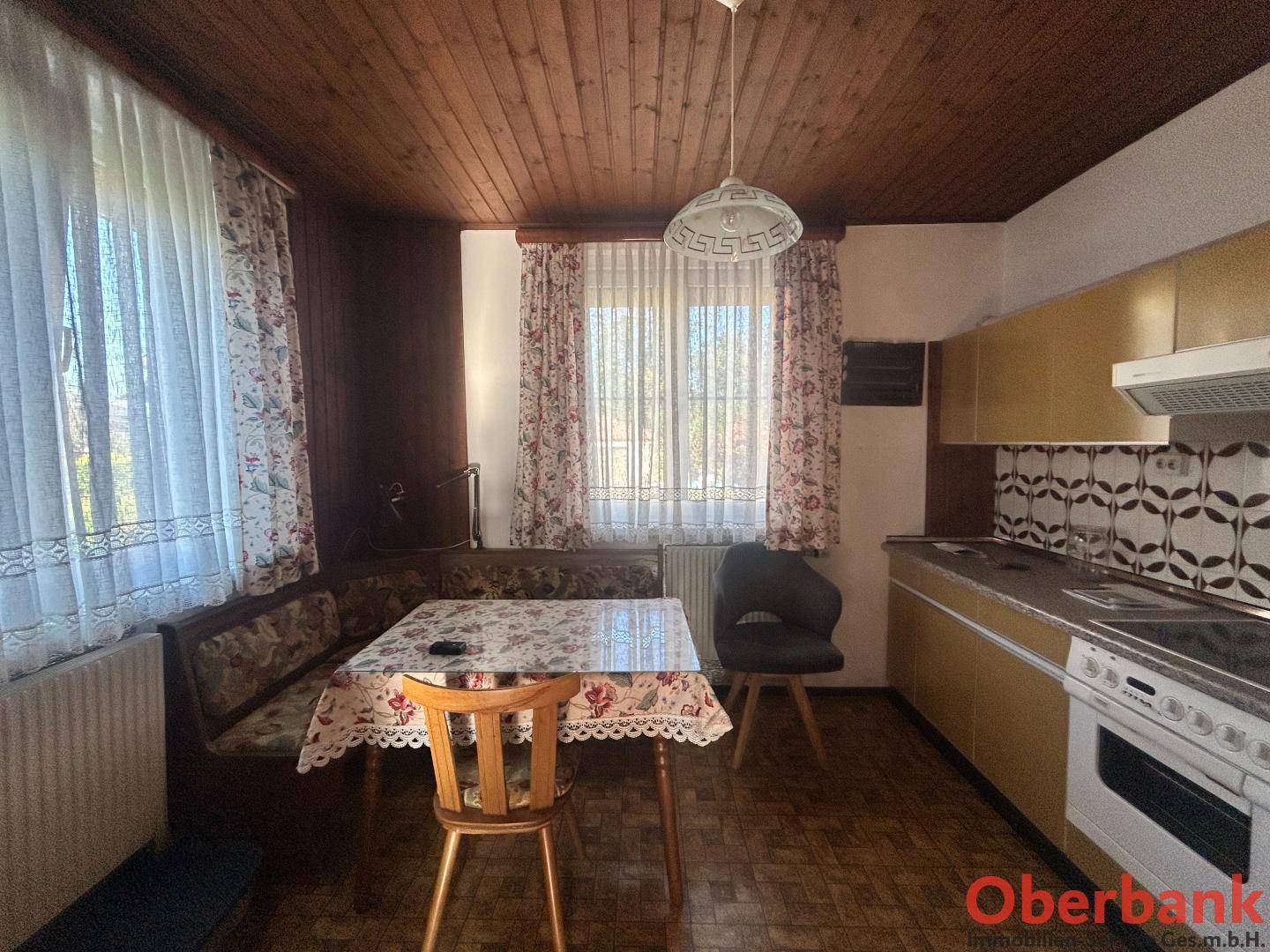 Gemütliche Wohnküche mit Essbereich, Holzdecke und traditionellen Fliesen in warmem Ambiente.