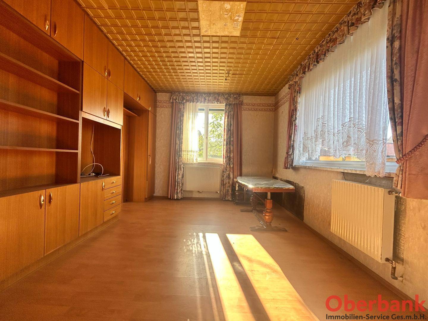 Geräumiges Schlafzimmer mit Einbauschränken, Holzdecke und Parkettboden in hellem Licht.