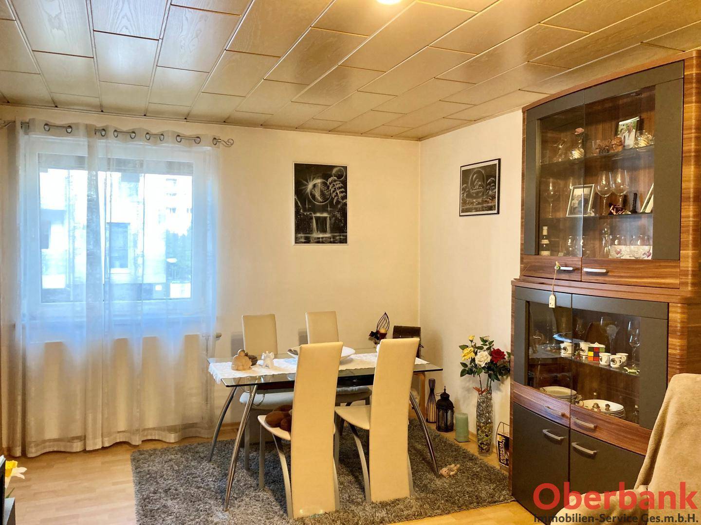 Gemütlicher Essbereich mit Holzboden, Esstisch und einem großen Vitrinenschrank.