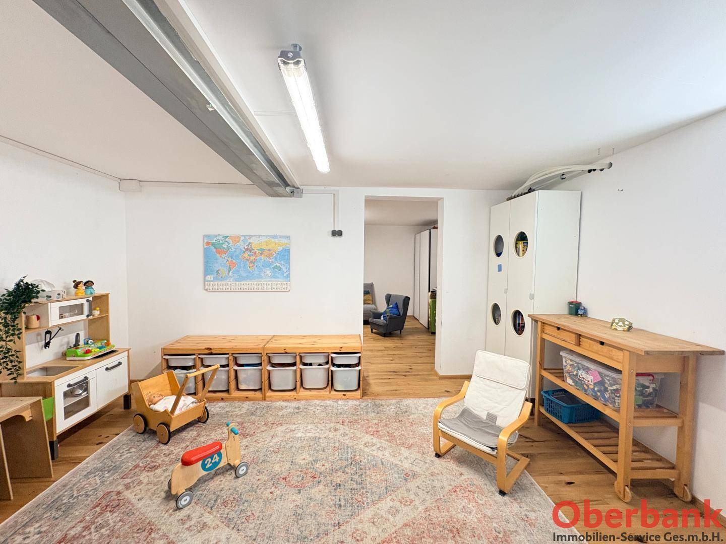 Freundliches Kinderzimmer mit Spielbereich, Teppich und praktischen Aufbewahrungsmöbeln.