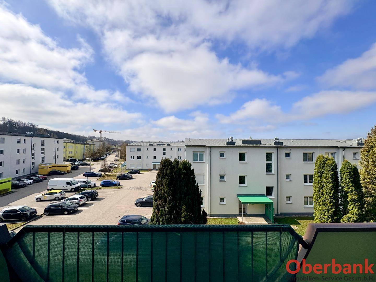 Ausblick vom Balkon auf die umliegenden Wohngebäude und den Parkplatz.