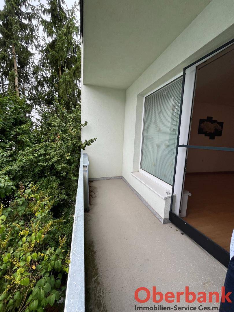 Schmaler Balkon mit Metallgeländer und Zugang zu einem Innenraum.