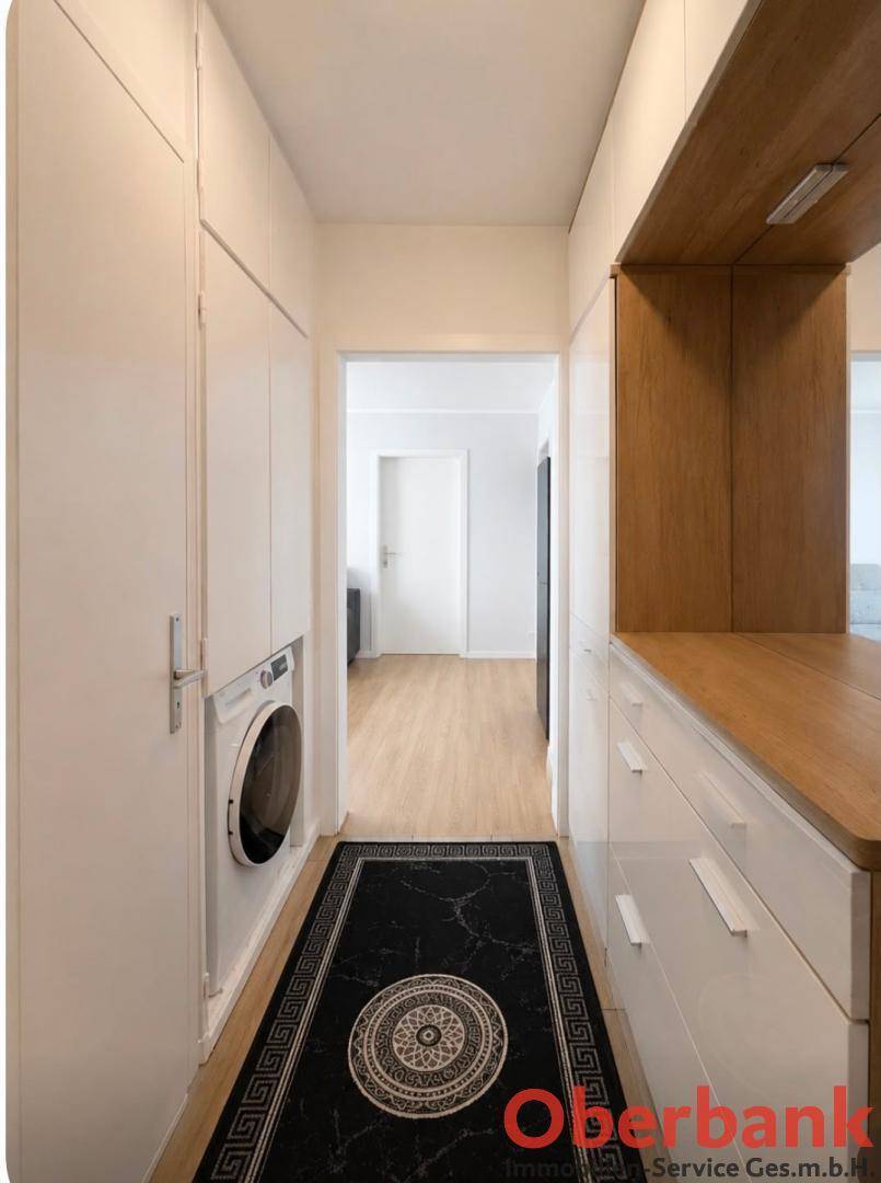 Funktionaler Hauswirtschaftsraum mit Waschmaschine, Einbauschränken und Holztheke.