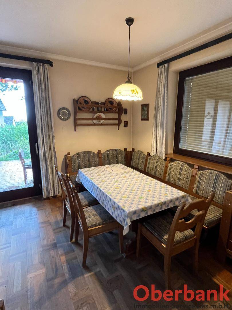 Esszimmer mit Holztisch, Eckbank und Zugang zu einem Außenbereich, ideal für gesellige Mahlzeiten.