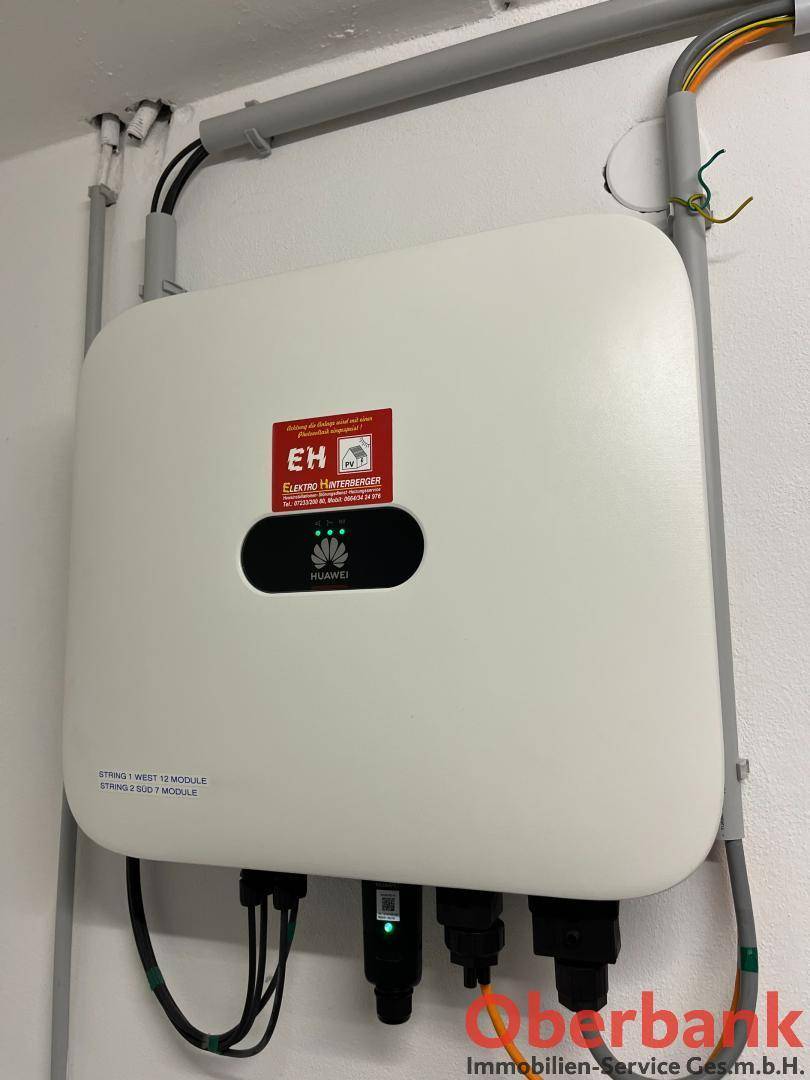 Wechselrichter für die Photovoltaikanlage, installiert an der Wand in einem Technikraum.