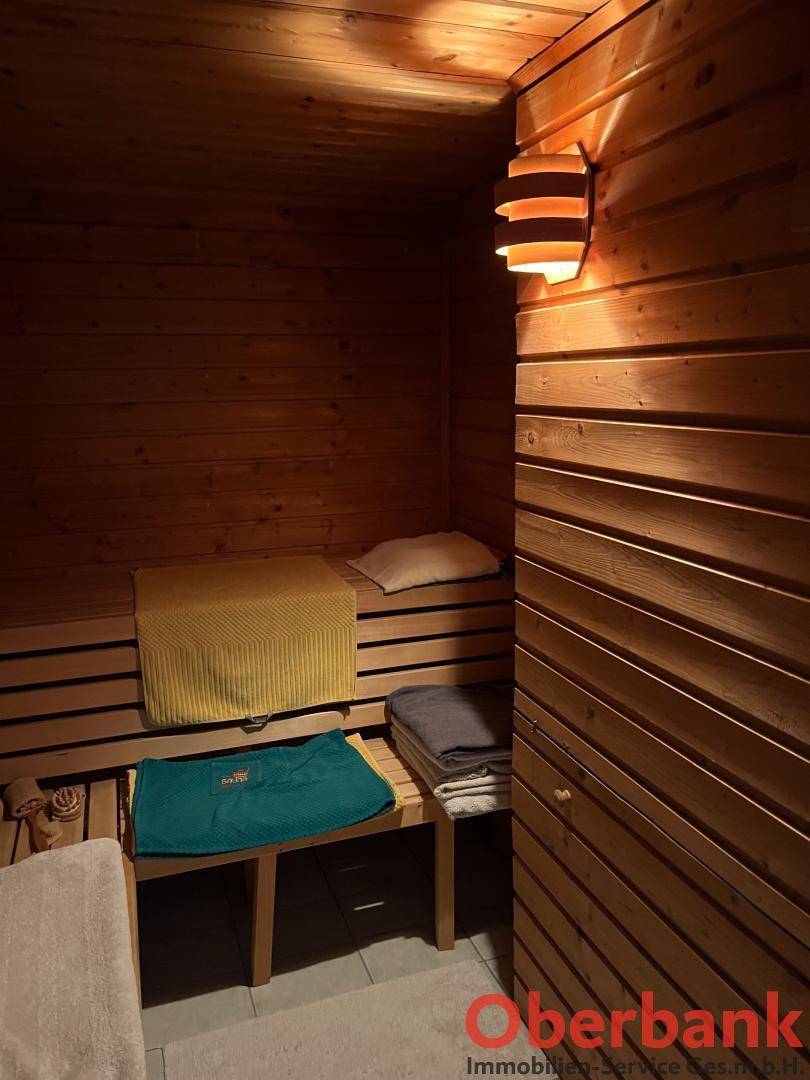 Gemütliche Holzsauna mit Bänken und indirekter Beleuchtung für entspannende Momente.