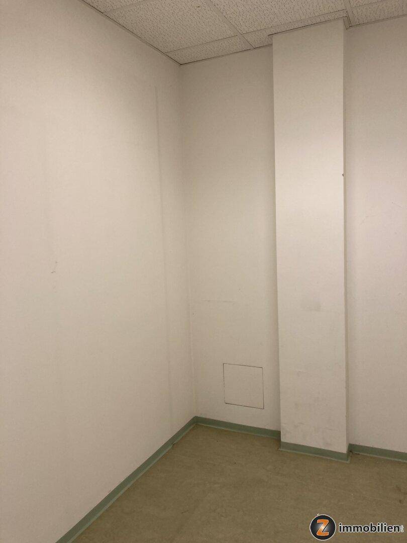 Leerer Raum mit weißen Wänden und einem Pfeiler, bietet flexible Nutzungsmöglichkeiten.