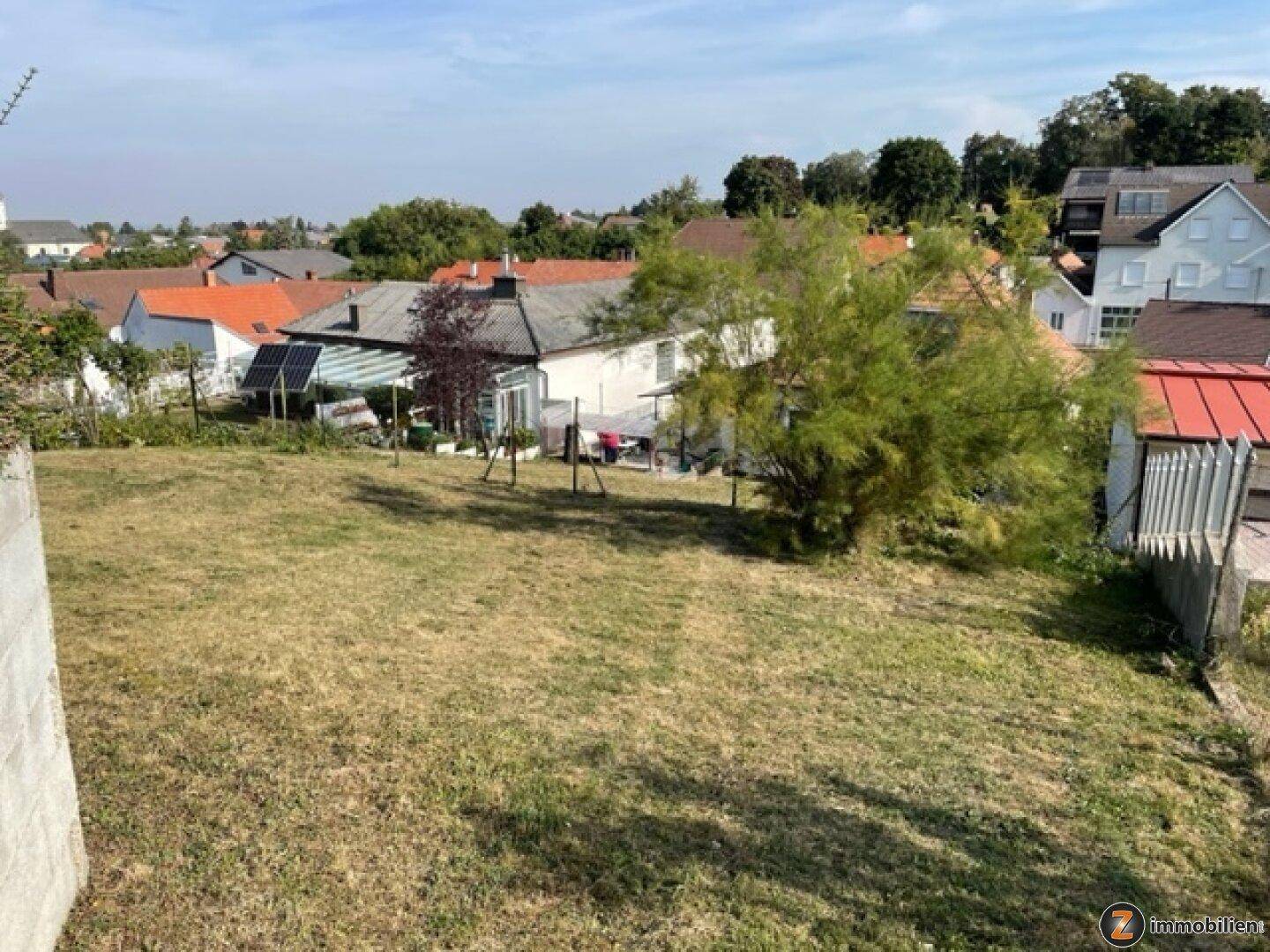 Weitläufiger Gartenbereich mit Rasenfläche und Blick auf die umliegenden Häuser und Landschaft.