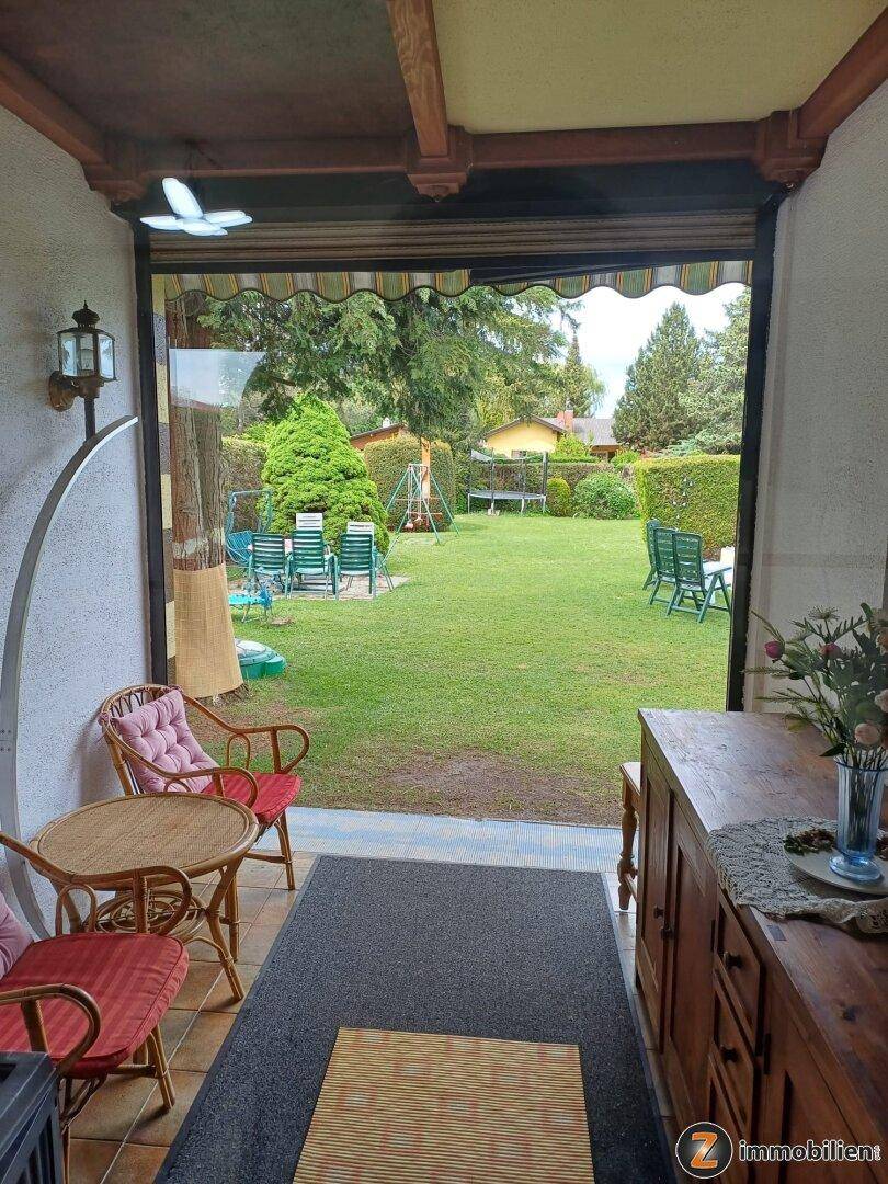 Heller Innenbereich mit Blick auf den Garten und gemütlicher Sitzgelegenheit.