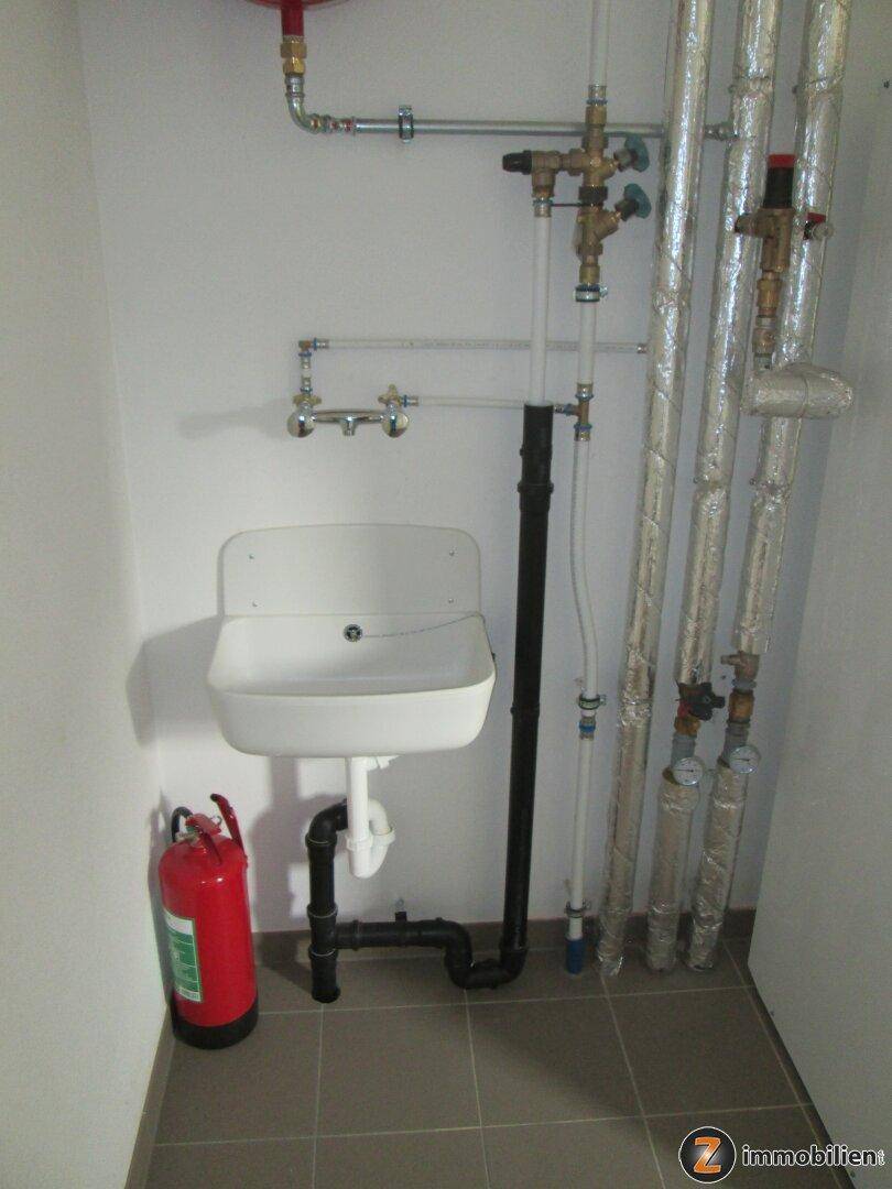 Technikraum mit Heizungsanlage, Rohren und elektrischen Installationen.