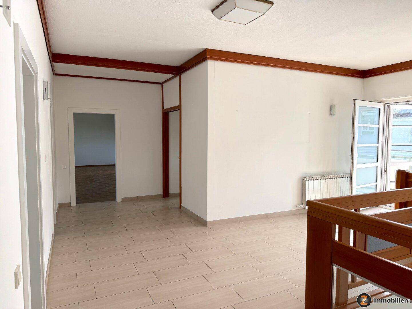 Geräumiger Flur mit Fliesenboden und Zugang zu einem Balkon oder einer Loggia.