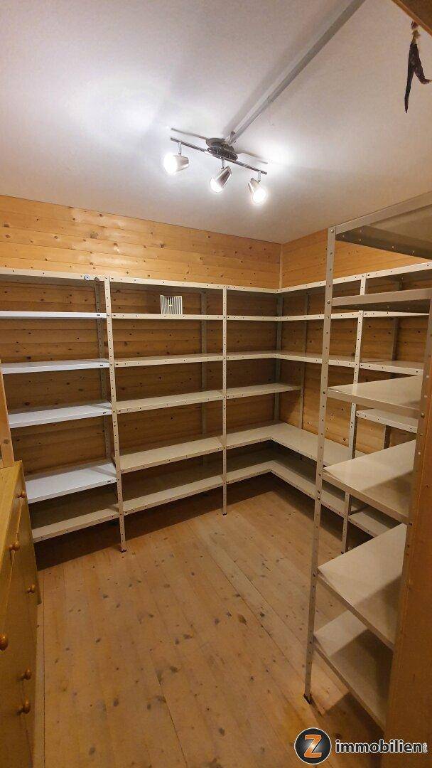 Geräumiger Abstellraum mit Holzverkleidung, Holzboden und praktischen Regalsystemen.