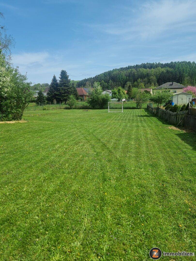 Weitläufige Rasenfläche mit Fußballtor und Blick auf die umliegende Hügellandschaft.