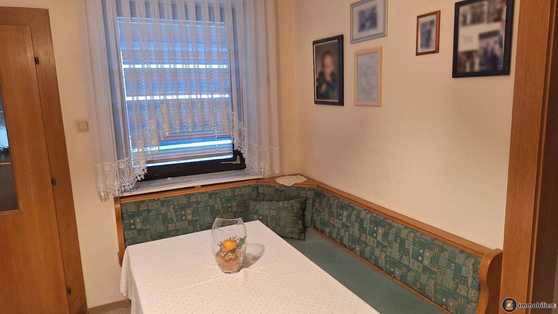 Heller Essbereich mit grüner Eckbank und Fenster mit Jalousien, ideal für Familienmahlzeiten.
