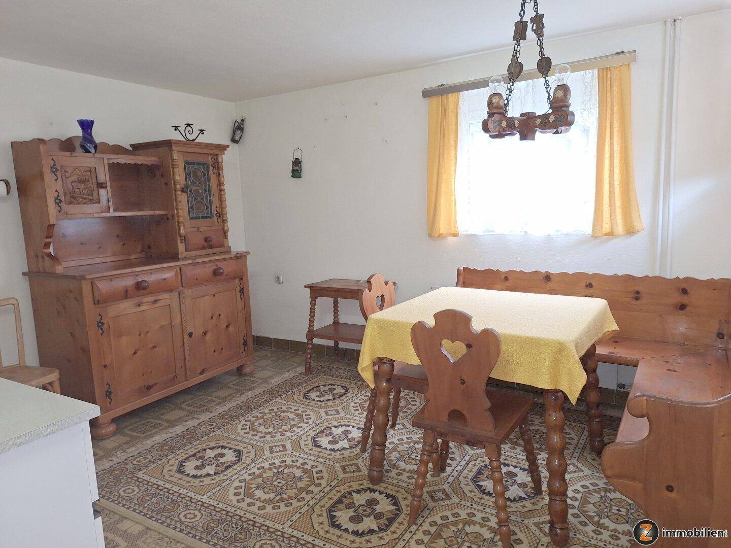 Rustikaler Essbereich mit Holztisch, Bank und Schrank, ideal für gemütliche Mahlzeiten.