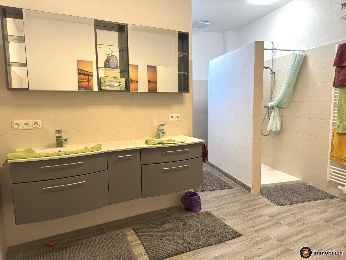 Geräumiges Badezimmer mit Doppelwaschbecken, großem Spiegelschrank und begehbarer Dusche.
