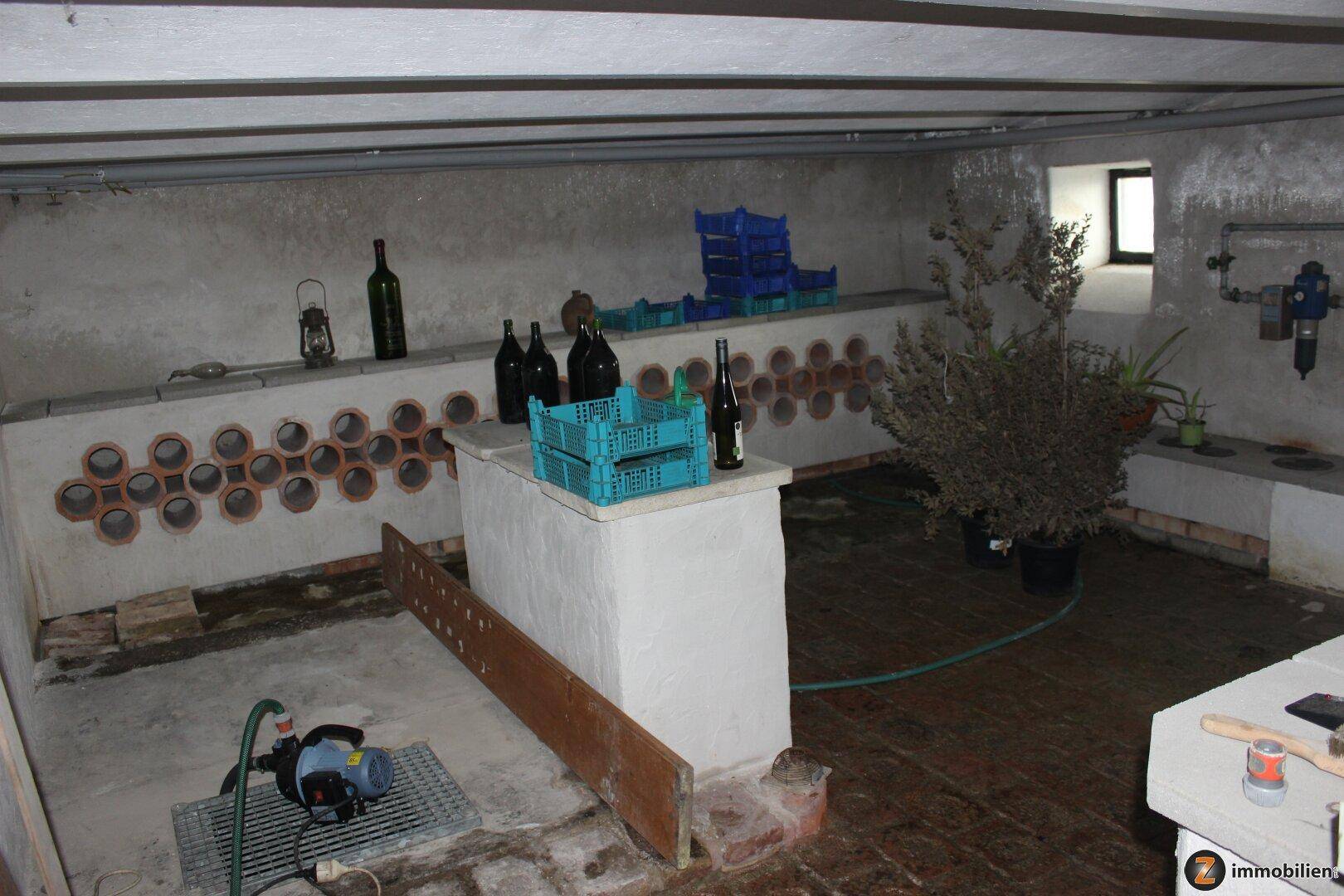 Rustikaler Weinkeller mit Flaschenregalen und einem kleinen Fenster.