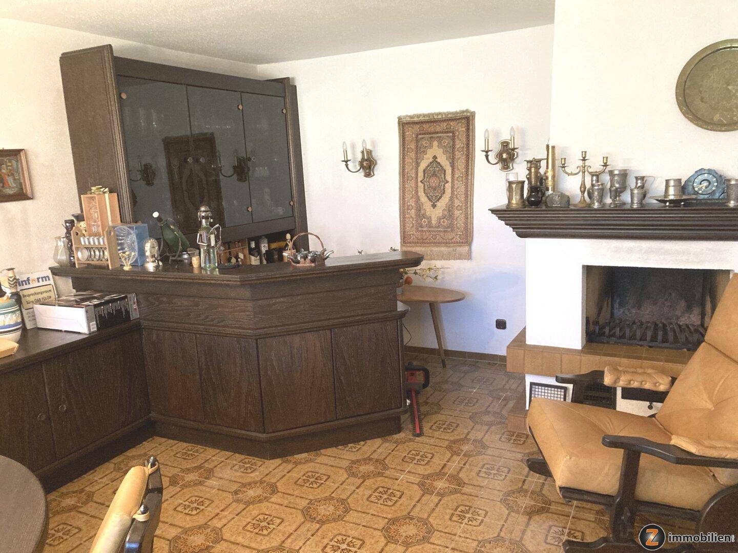 Wohnzimmer mit Kamin, Hausbar und gemustertem Fliesenboden, ideal für gesellige Abende.