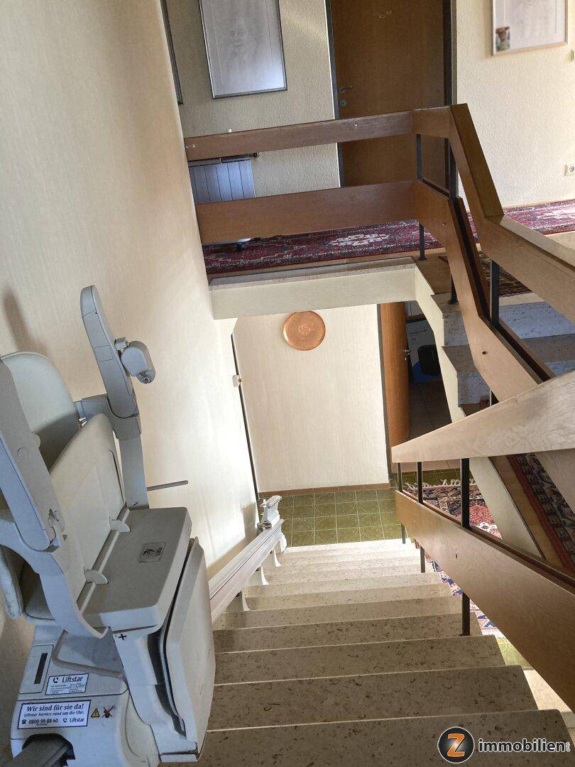 Treppenhaus mit Treppenlift für barrierefreien Zugang zu den oberen Etagen.