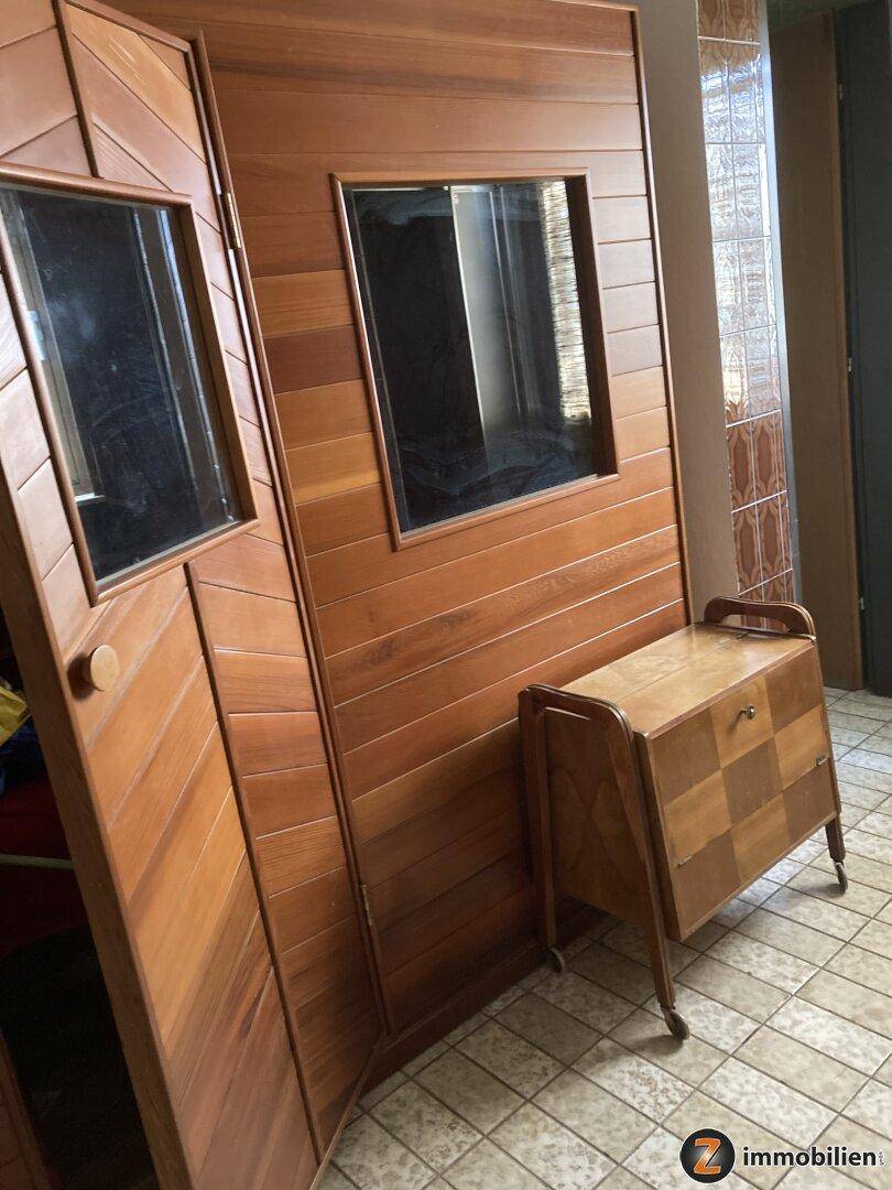 Holzkabine einer Sauna mit Fenster und angrenzendem Fliesenboden.