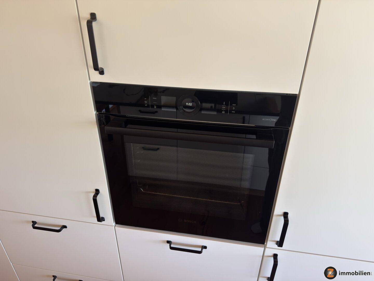 Integriertes Backofen in der modernen Einbauküche mit weißen Fronten.