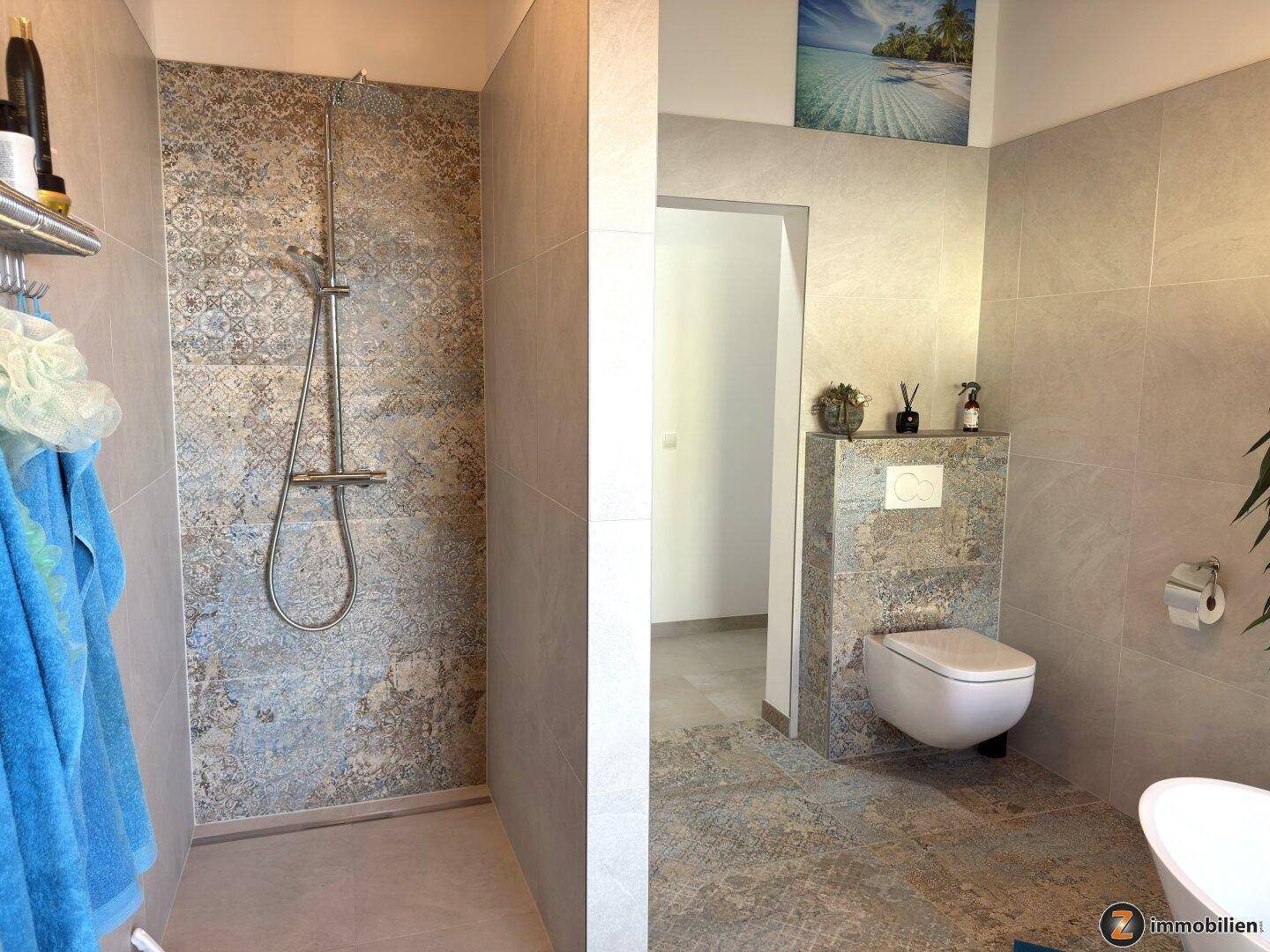Geräumiges Badezimmer mit ebenerdiger Dusche, Wand-WC und dekorativen Fliesen.