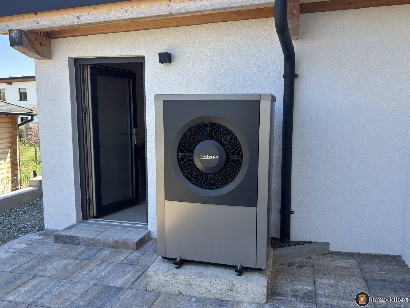 Moderne Wärmepumpe der Marke Buderus an der Außenwand des Hauses installiert.