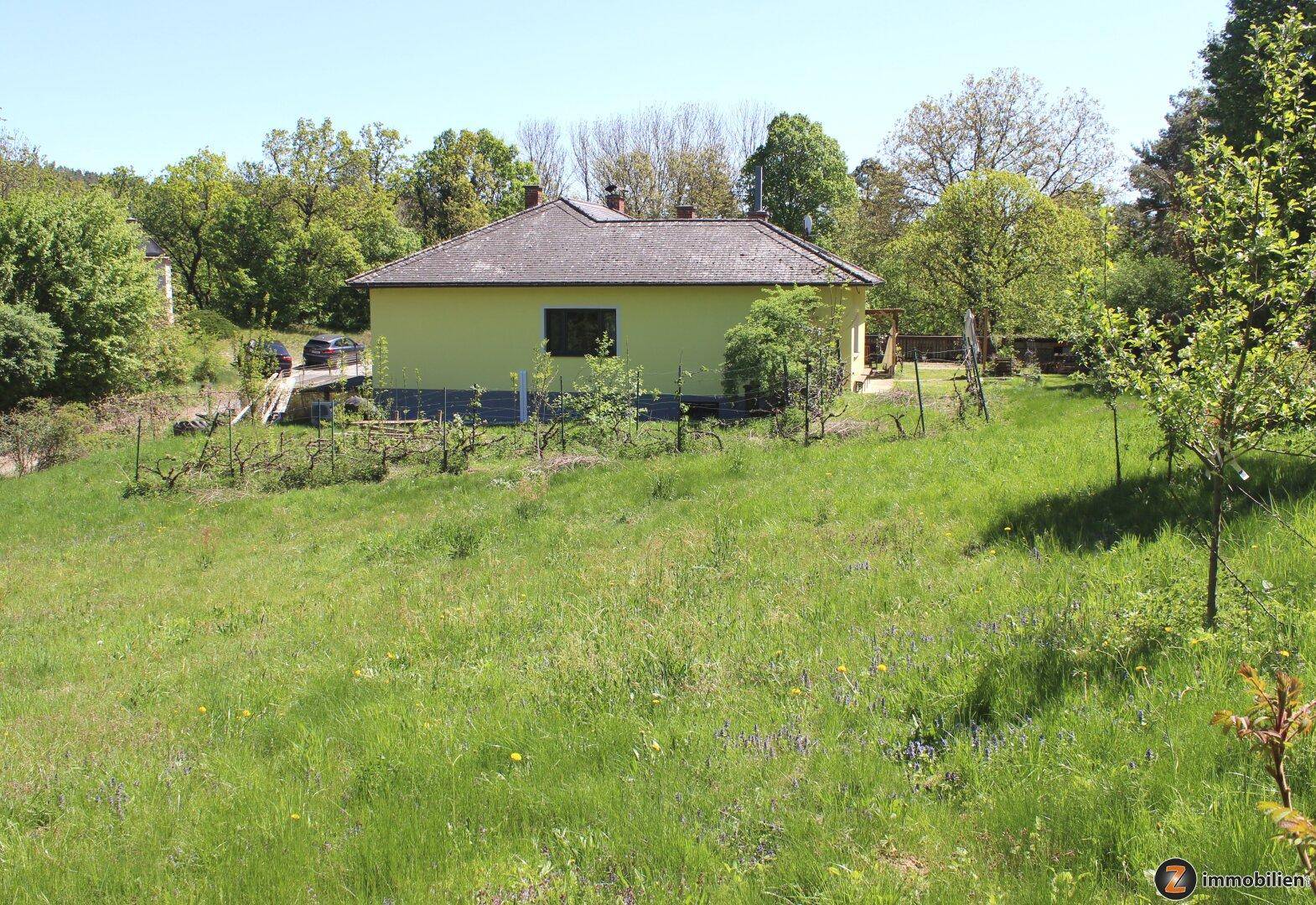 Weitläufige Grünfläche vor dem Haus mit Blick auf die umliegende Landschaft.